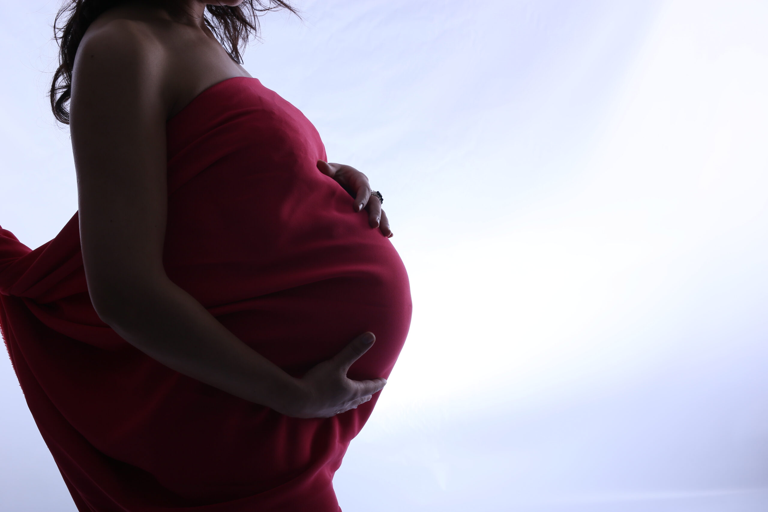 Stock image of a Black pregnant woman holding her belly